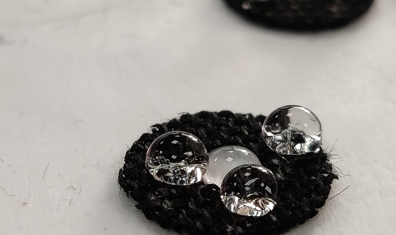 Close-up of coalescing filter material showing water droplet beading on hydrophobic surface treatment